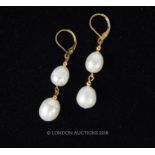 A pair of South Sea two pearl drop earrings set in 14 carat yellow gold.