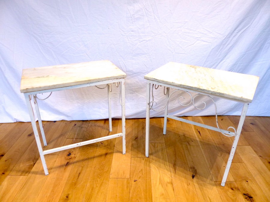 A pair of white painted metal low tables with marble tops