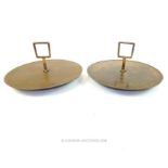 A pair of circular bronze trays with handles