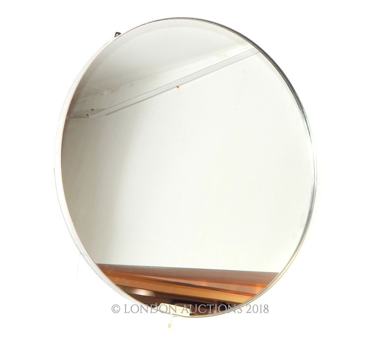 A contemporary circular mirror with a silvered frame