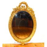 A late 19th century oval gilt gilt framed wall mirror