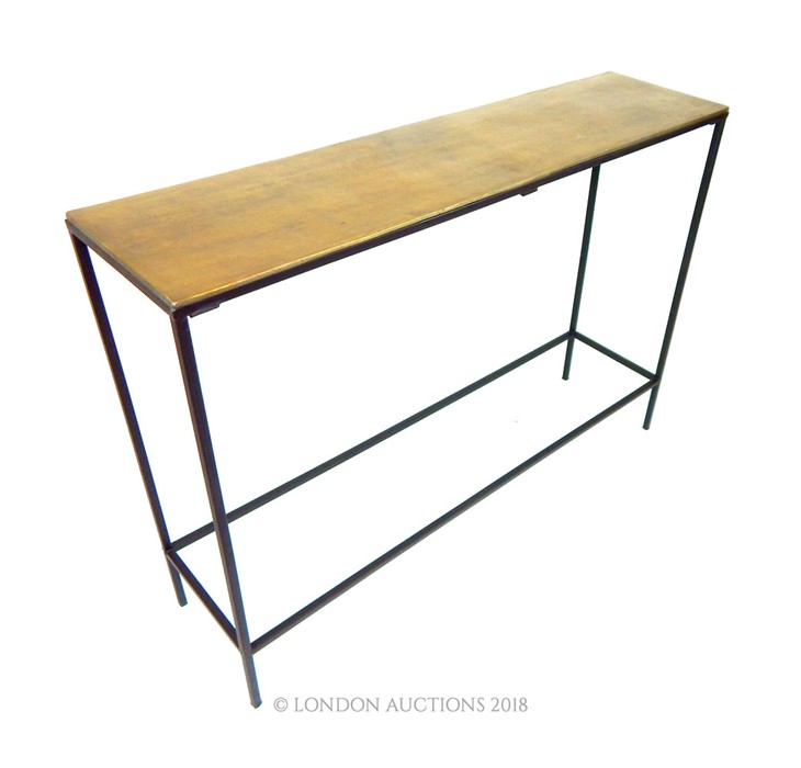 A contemporary console table with a bronzed top