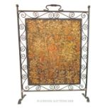 A wrought iron fire screen with a tapestry panel