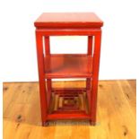 A Chinese red lacquered three tier occasional table