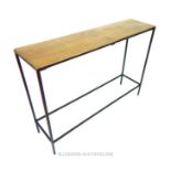 A contemporary console table with a bronzed top