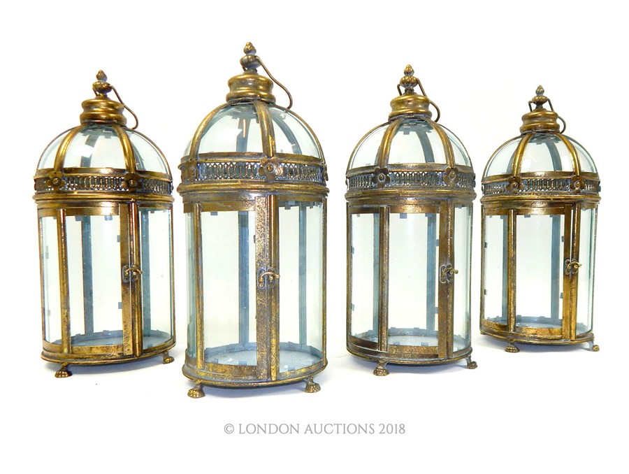 A set of four circular storm lanterns.