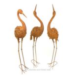 A set of three painted and distressed metal figures of cranes