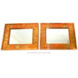 A pair of rectangular, copper-framed mirrors.