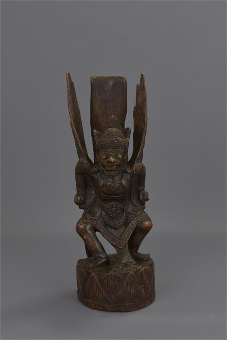 A FAR EASTERN CARVED WOODEN FIGURE