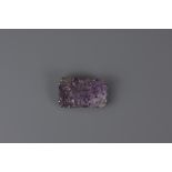 A CHINESE CARVED AMETHYST STONE IN BROOCH
