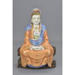 A Chinese 20th century porcelain Guanyin figure seated on separate carved wooden stand. Total 30cm t