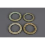 A group of four Chinese 18/19th century jade bangles. 6.5cm - 7.5cm diameters (4)