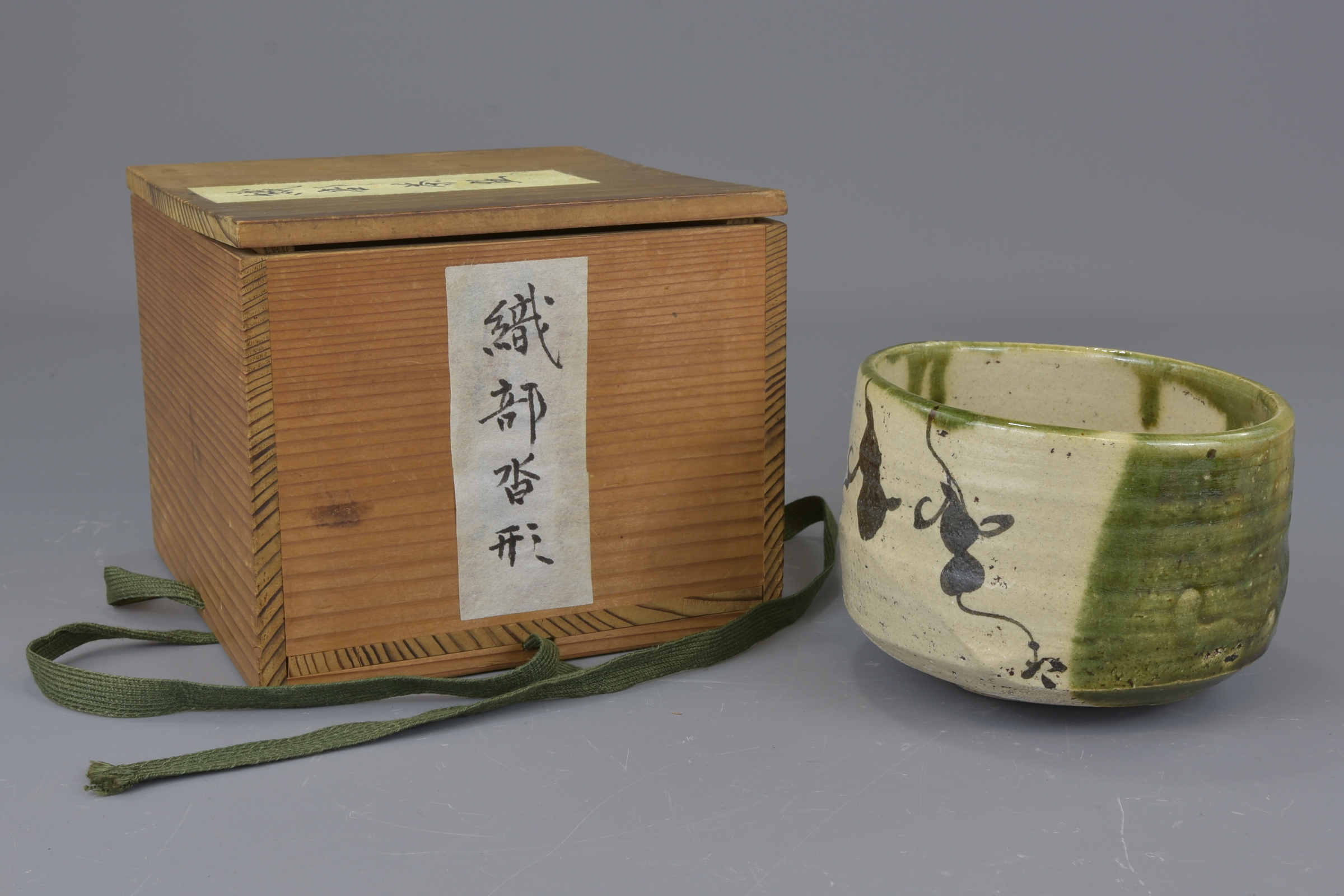 A Japanese early 19th century green glazed tea bowl with black double gourd decorations. 12cm Proven