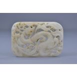 A Chinese Ming or later white jade belt buckle carved through with dragon decoration. 8cm x 5.5cm