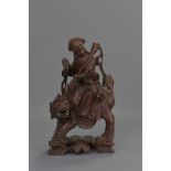 A Chinese 19th century carved wooden figure of Guanyin seated on a lion. 29 cm tall