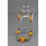 A Tibetan amber resin beaded necklace with silver-coloured metal.