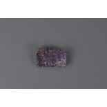 A Chinese 19th century carved amethyst stone mounted in a metal brooch. 3.5cm x 6cm