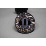 A bronze TSUBA with gilded decoration depicting flowers.