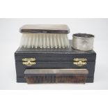 An unused cased silver backed gentleman's brush and comb set plus a napkin ring.