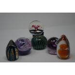 A collection of eight assorted glass paperweights.