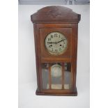 A 1930s oak cased wall clock.