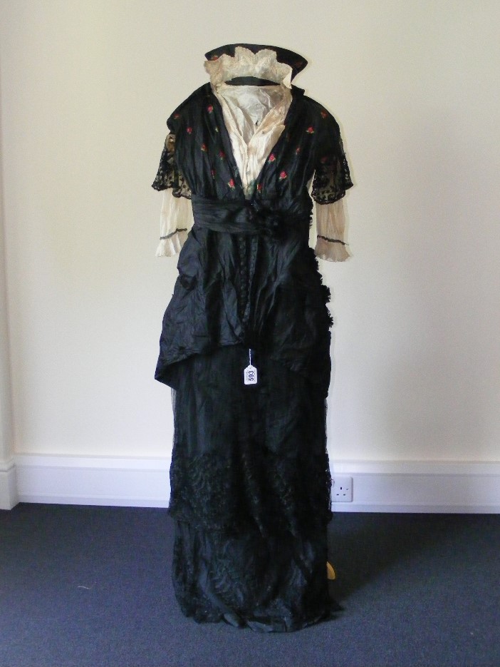 A day/afternoon dress circa 1880, black silk and net with the silk embroidered with flowers.