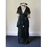 A day/afternoon dress circa 1880, black silk and net with the silk embroidered with flowers.