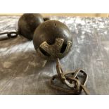 A curio antique wooden ball and chain, possibly from the Middle East.