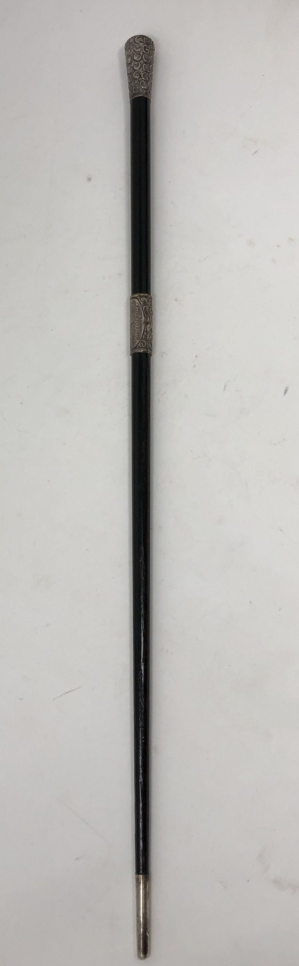 An ebonised conductor's baton with embossed silver handle.