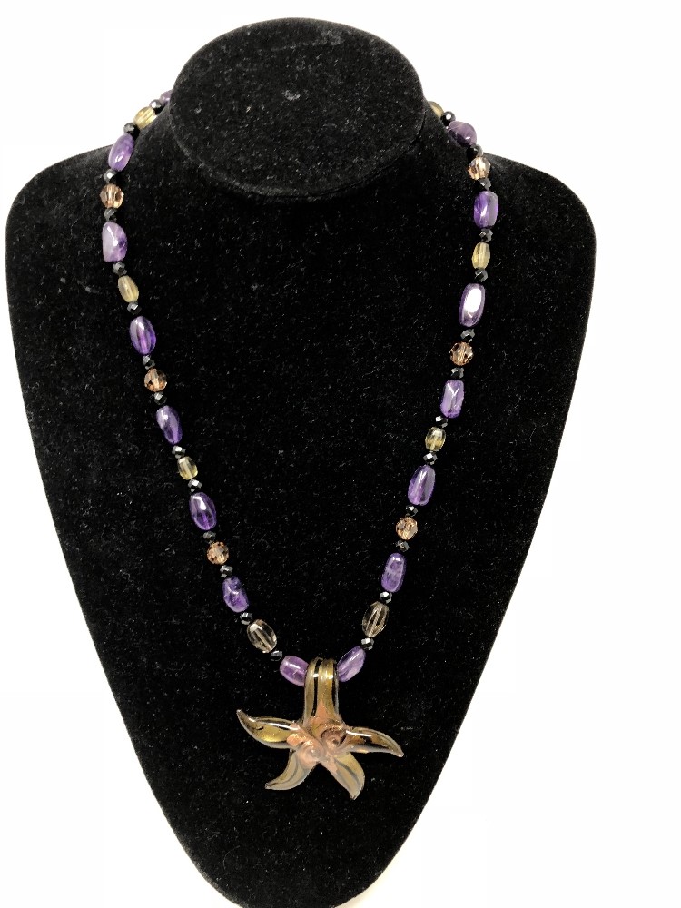 An unusual necklace set with amethyst beads and a Murano Glass starfish, with silver clasp.