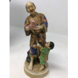 A Japanese ceramic figure of a man and boy.