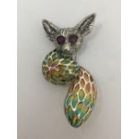 A silver Plique A Jour brooch/pendant in the form of a bush-baby with ruby eyes.