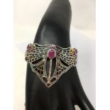 A silver and Plique A Jour cuff bangle in the form of a butterfly with ruby cabochons.