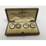 A cased set of four 18ct gold, enamel and mother of pearl dress buttons.