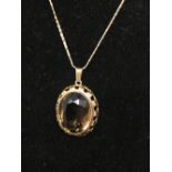 A silver pendant necklace with large smoky quartz.