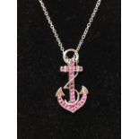 A silver and pink sapphire pendant necklace in the form of an anchor.