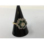 An 18ct gold, emerald and diamond cluster dress ring.