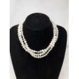 A freshwater pearl triple strand necklace with silver clasp.