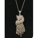 A silver pendant necklace in the form of a fox with ruby eyes.