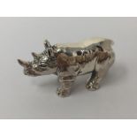 A cast silver figure of a rhinoceros.