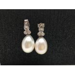 A fine pair of white gold (possibly 18ct) pearl and diamond drop earrings.