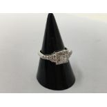 An 18ct white gold diamond ring with central princess cut diamond with 22 further diamonds.