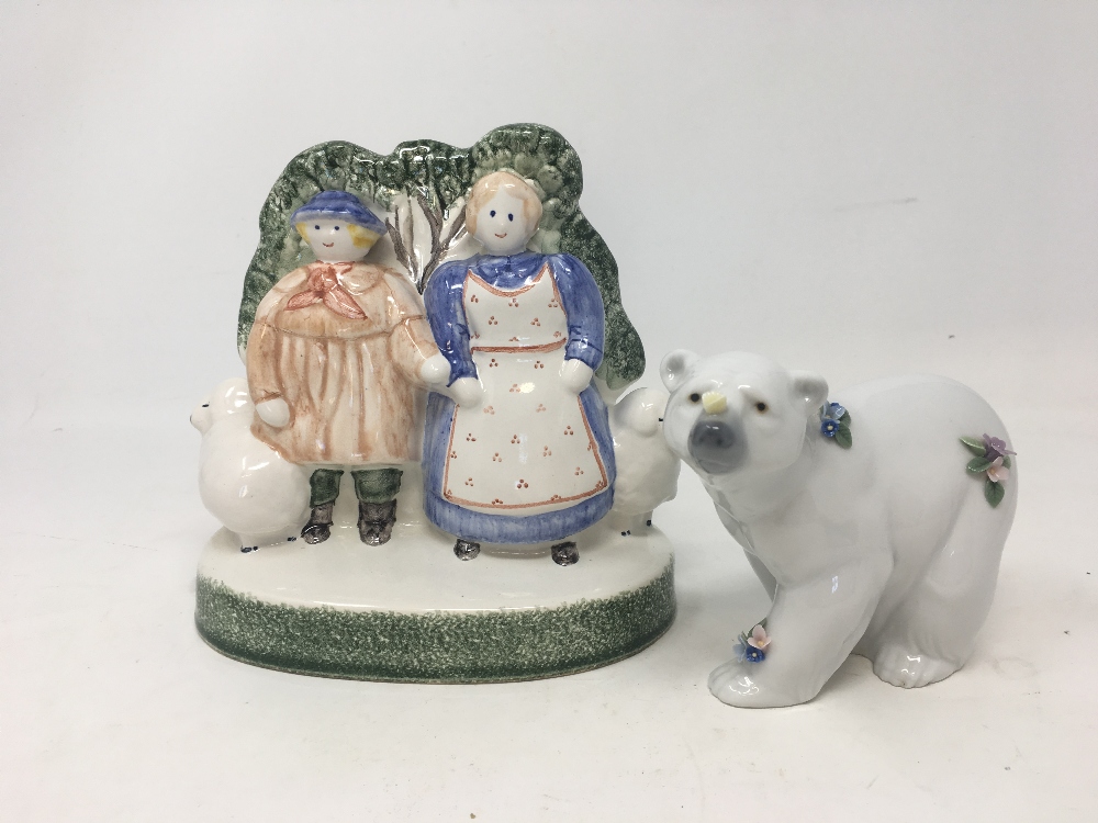 A RYE Pottery ceramic figure and a Lladro polar bear decorated with flowers.