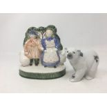A RYE Pottery ceramic figure and a Lladro polar bear decorated with flowers.