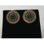 A pair of silver, CZ and faux emerald stud earrings.