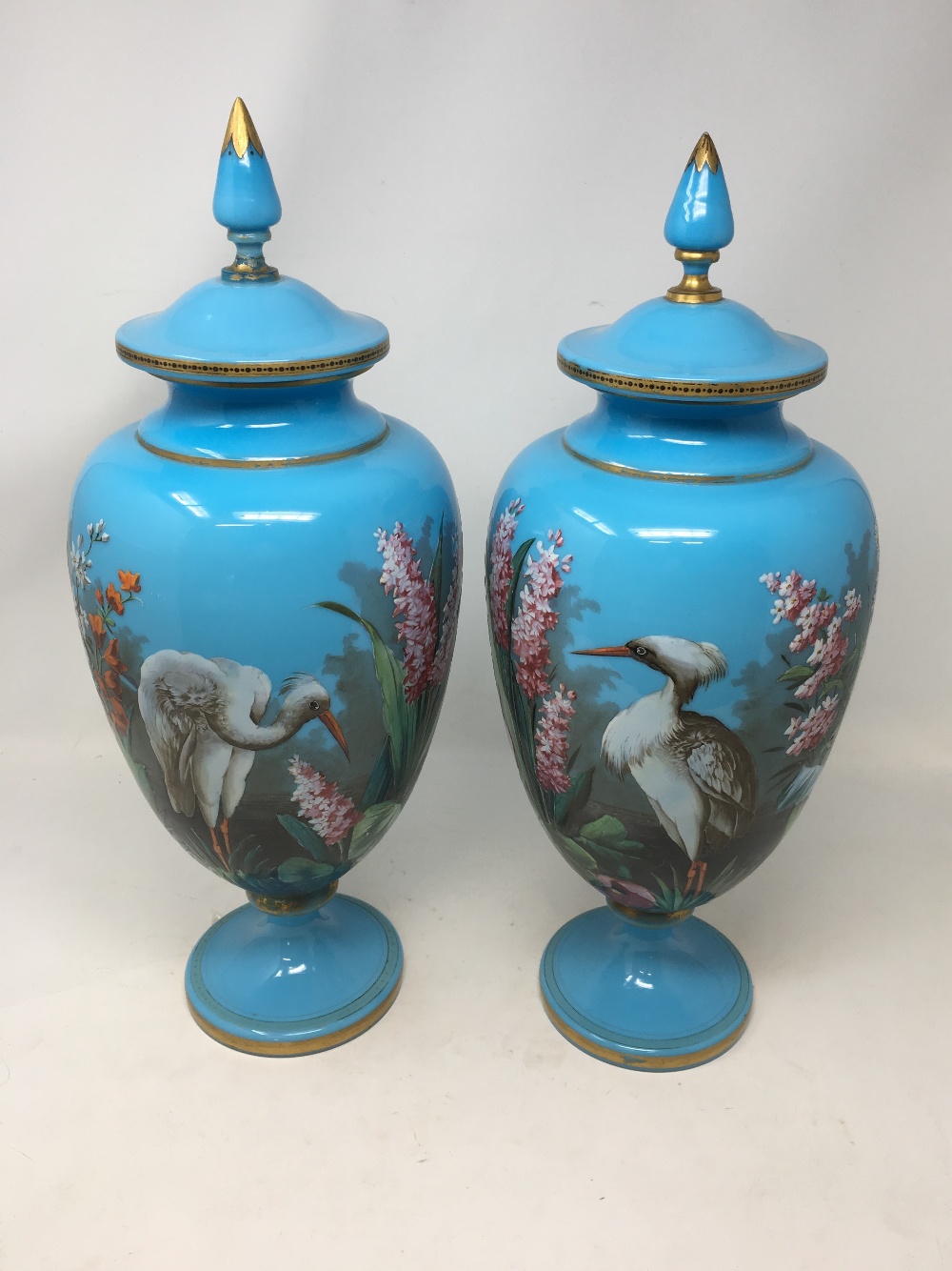 A pair of late 19th Century/early 20th Century painted opaline pedestal lidded vases.