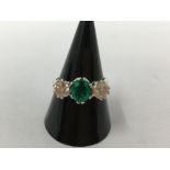 An 18ct white gold three stone emerald and diamond ring of 1.5ct.