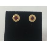 A pair of 18ct gold, ruby and diamond stud earrings of approximately 60 points.