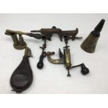 An assortment of vintage shot gun cartridge reloading tools, powder kegs and shot flasks.