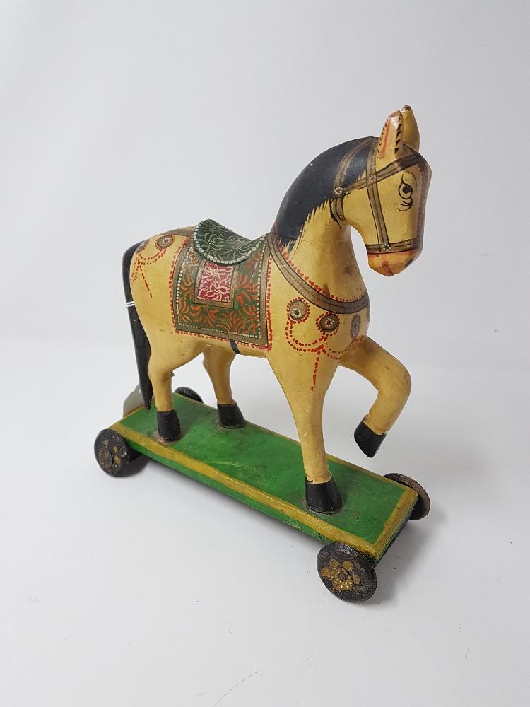 A contemporary painted model of a child's push along horse.